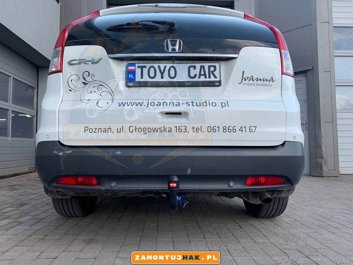 Zdjęcie przedstawia Hondę CR-V z zamontowanym wypinanym pionowo hakiem holowniczym westfalia a40v, zdjęcie jest zrobione z tyłu samochodu